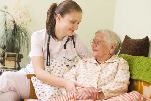 Home healthcare nurse providing comfort to elderly patient
