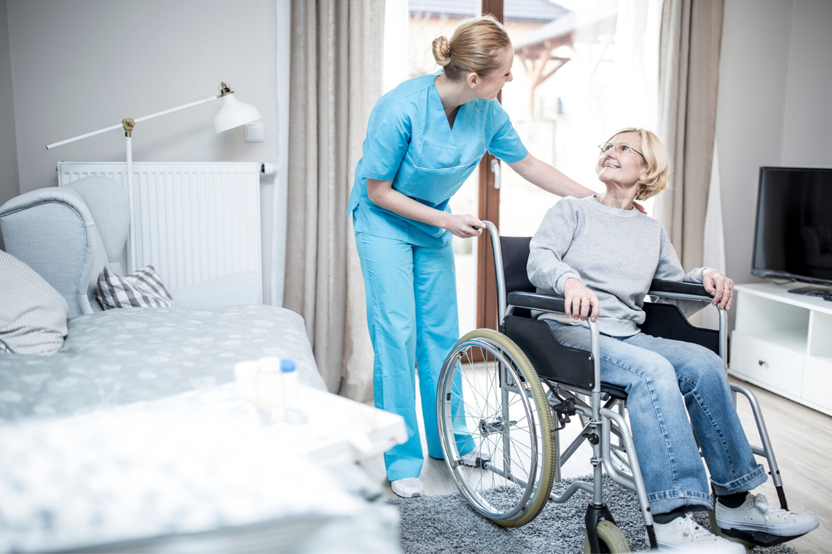 Nurse assisting elderly woman in wheelchair